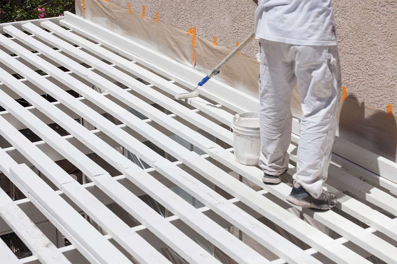 A man painting the roof of his home.